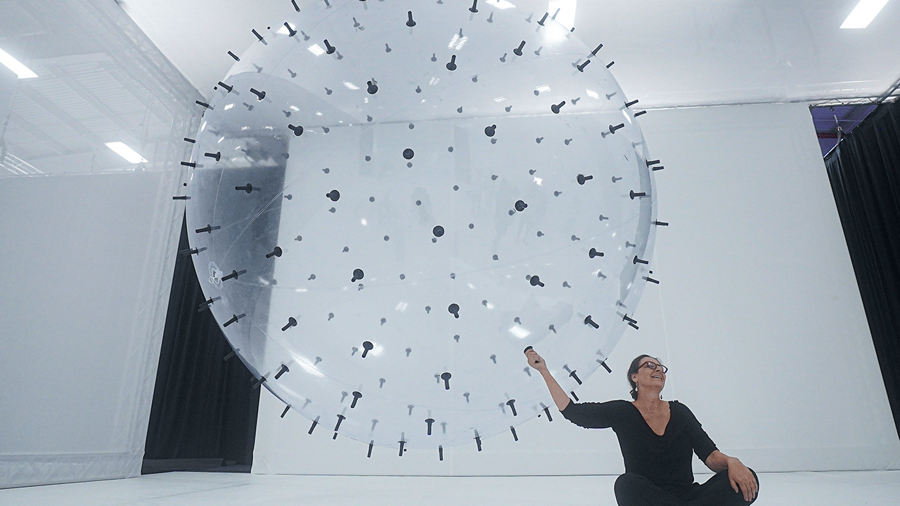 Artist Karina Smigla-Bobinski sitting with her "ADA" installation at the Balloon Museum