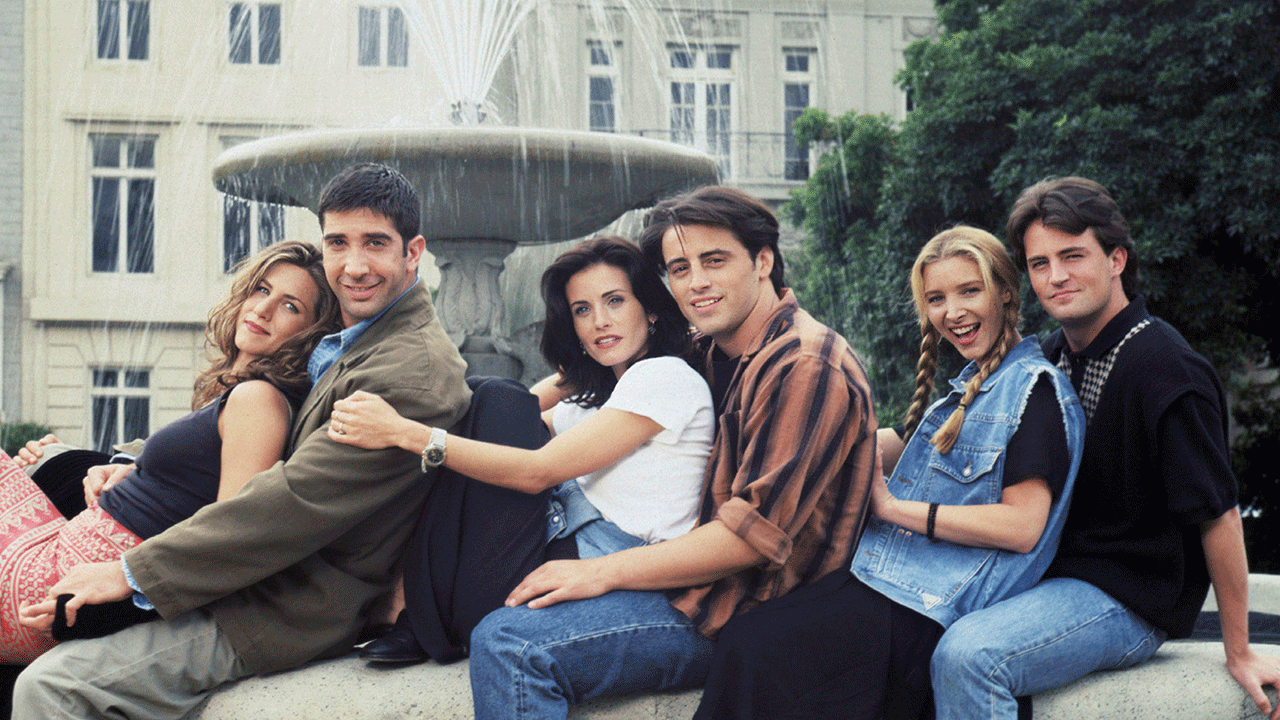 Cast of "Friends" sitting in front of fountain