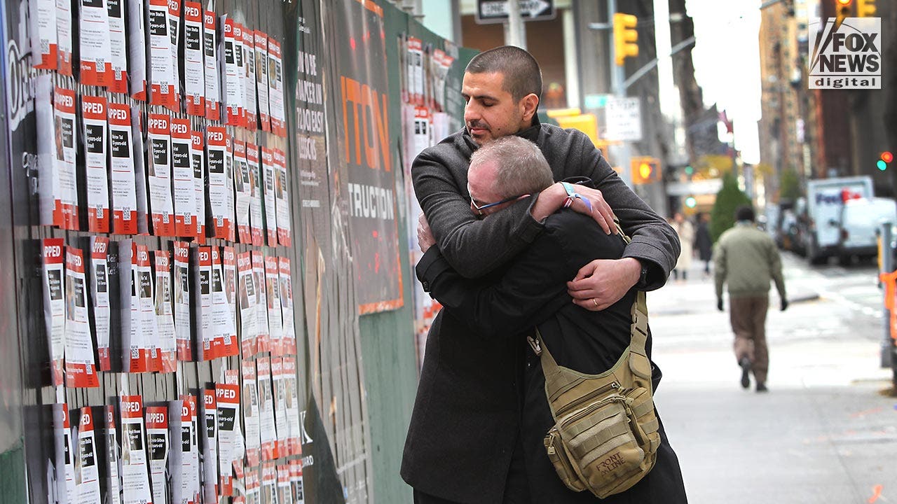 Michael Levy hugs Thomas Hand in front of kidnapped-by-Hamas posters in New York City, Wednesday, November 15, 2023. Hand, whose 8-year-old daughter is being held hostage, confronted a woman tearing down such posters recently in Manhattan. (Jennifer Mitchell for Fox News Digital)