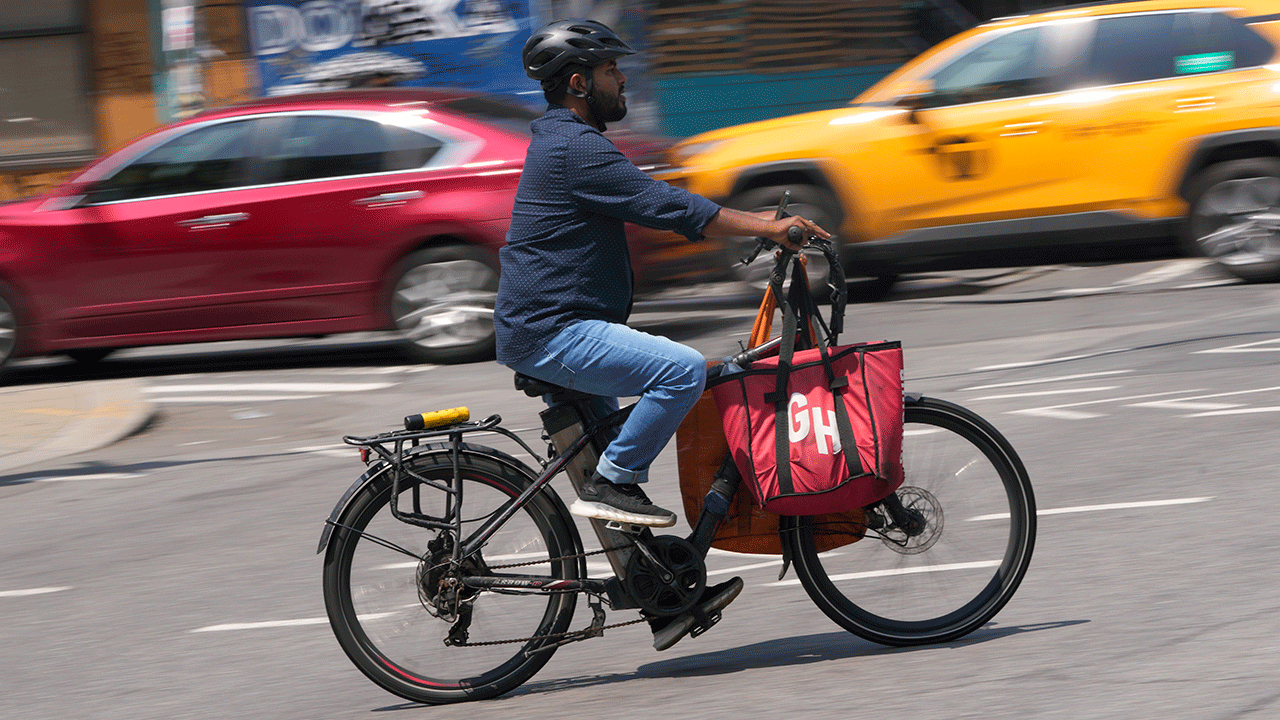 Delivery worker rides motorized bicycle