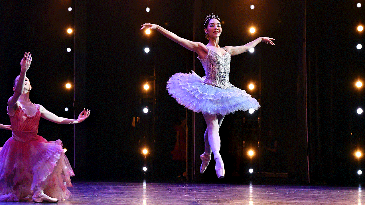 A dancer leaping in the air on stage
