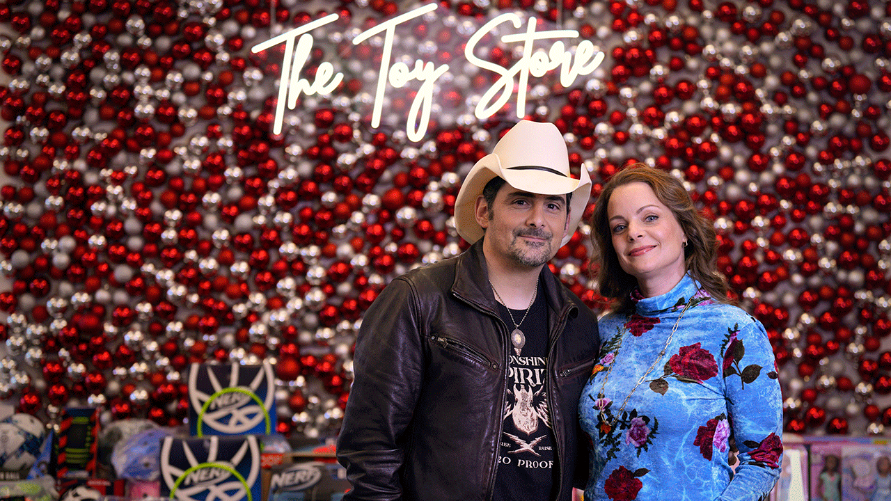 Brad Paisley and Kimberly Williams-Paisley in front of the Toy Store sign