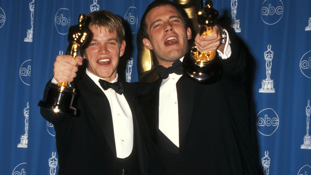 Matt Damon and Ben Affleck holding up their Oscars in the press room