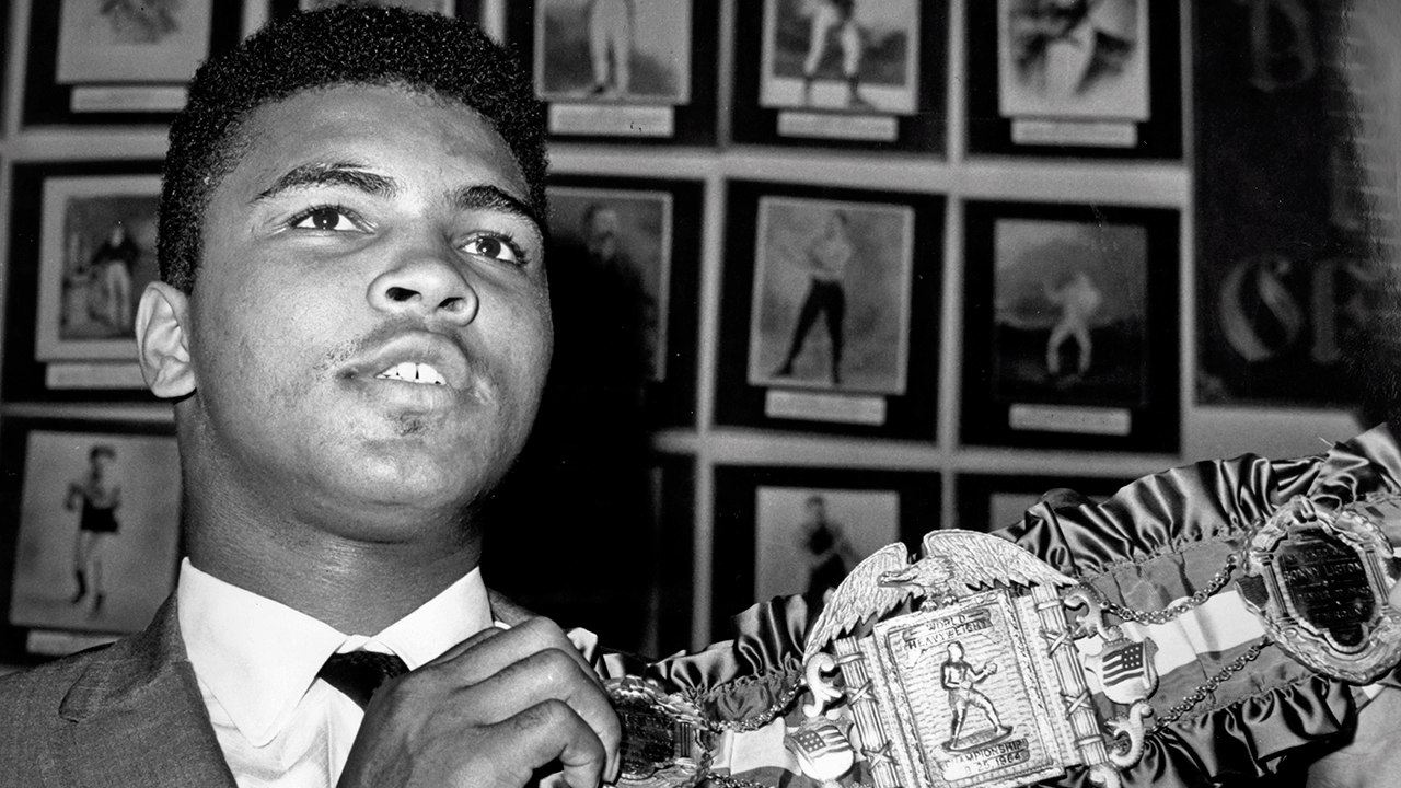 Muhammad Ali holding heavyweight champion belt