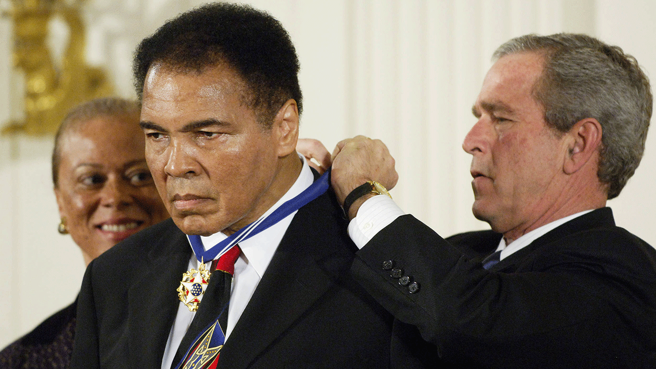The Presidential Medal of Freedom being placed around the neck of Muhammad Ali by President George Bush