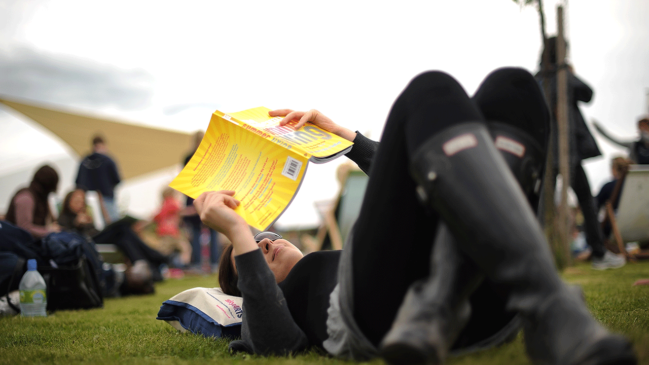 Person in the grass with a book