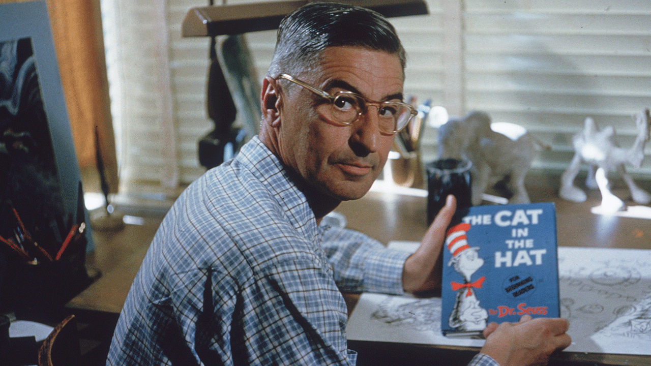 Dr. Seuss holding up "The Cat In The Hat"