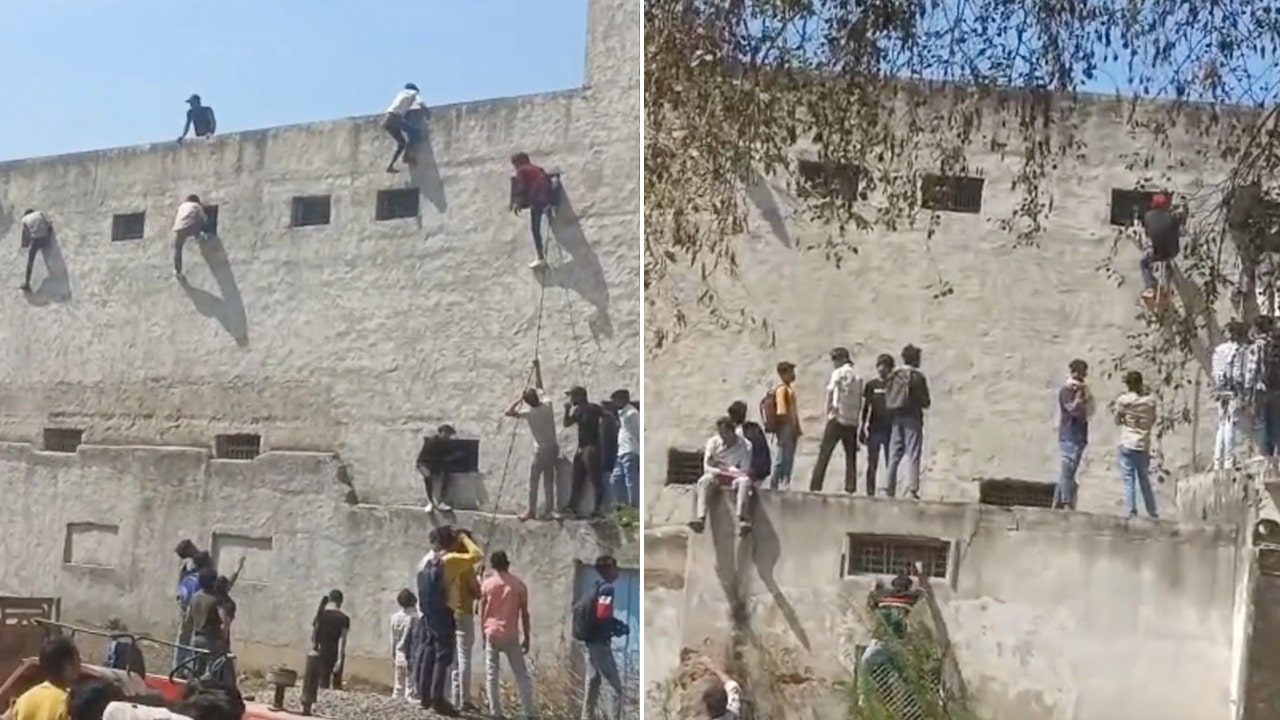 Students in India caught grabbing exam 'cheat sheets' from those who scaled school's walls