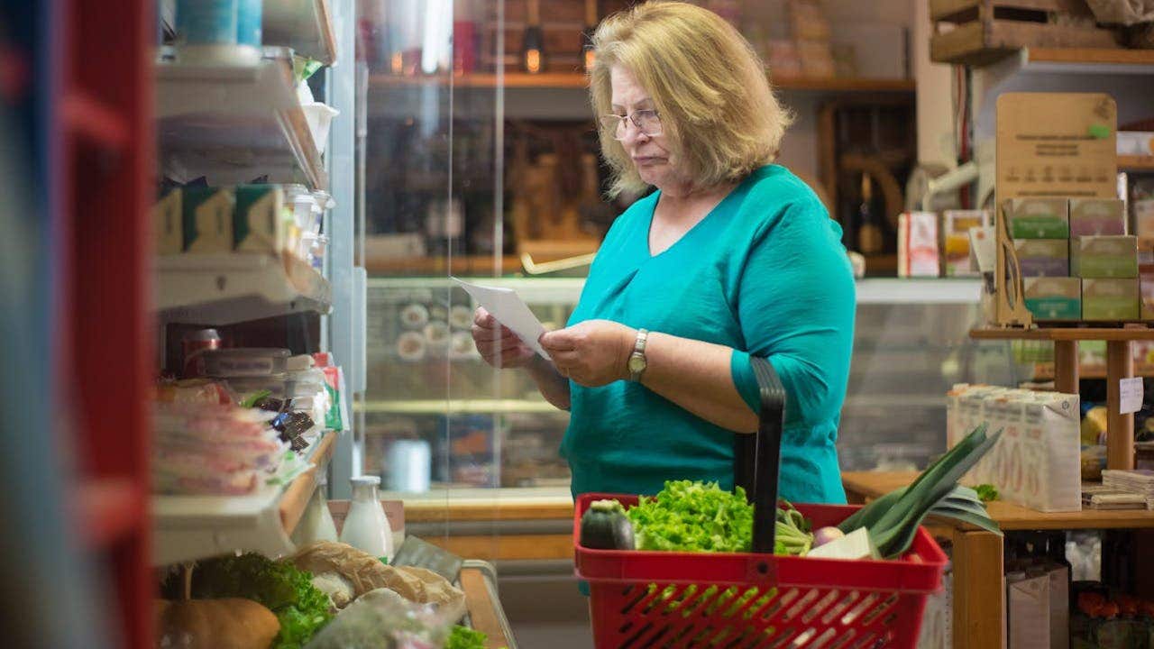 2 how to print your reminders app lists on your iphone to take wherever you go woman in green shirt looking at her grocery list