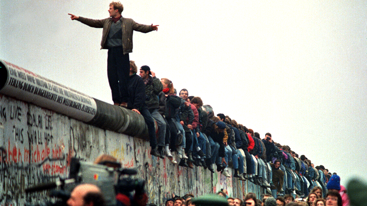 People stand on a section of the Berlin Wall at Potsdamer Platz. 