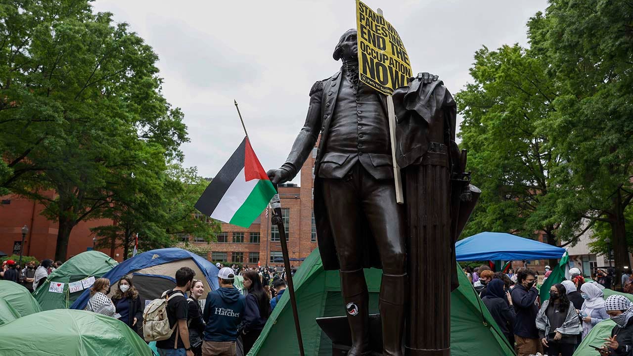 Signs and a Palestinian flag sit on a statue of George Washington at an encampment protest at the University Yard at George Washington University April 25, 2024 in Washington, DC. (Photo by Anna Moneymaker/Getty Images)