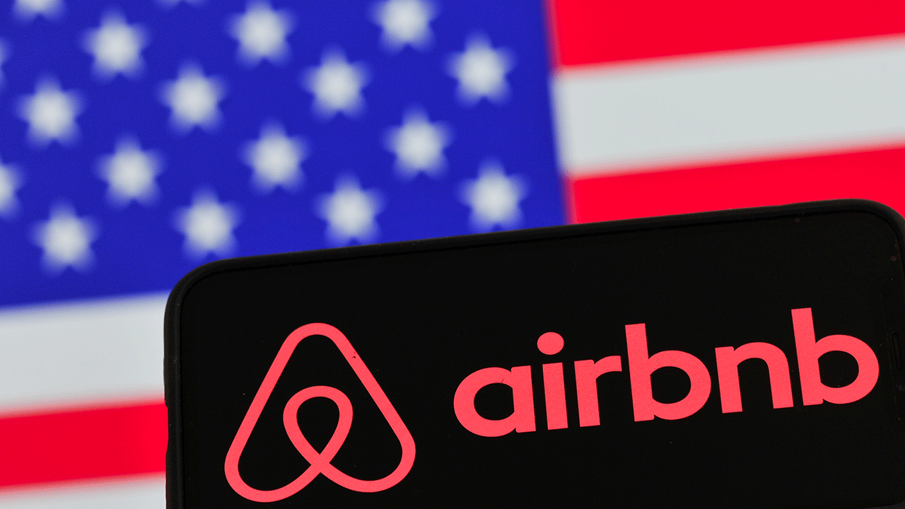 Airbnb logo in front of American flag