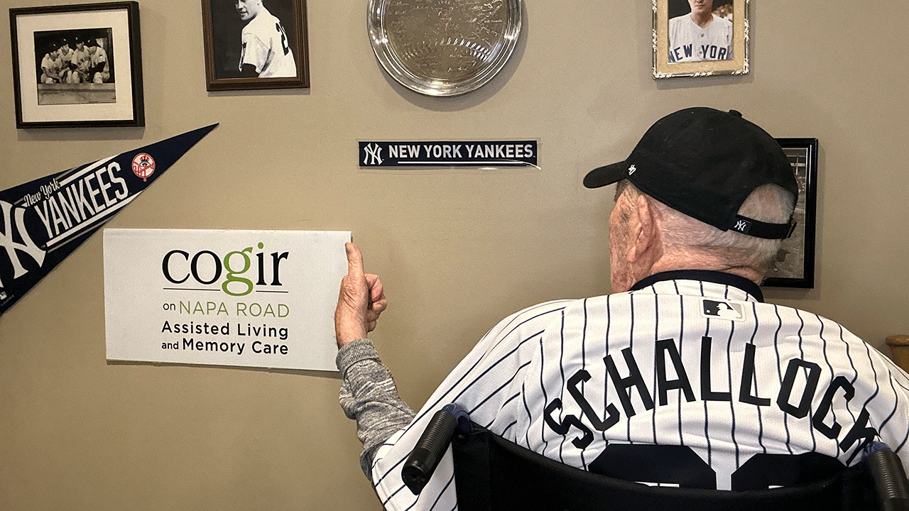 Art Schallock, the oldest living MLB player in front of memorabilia 