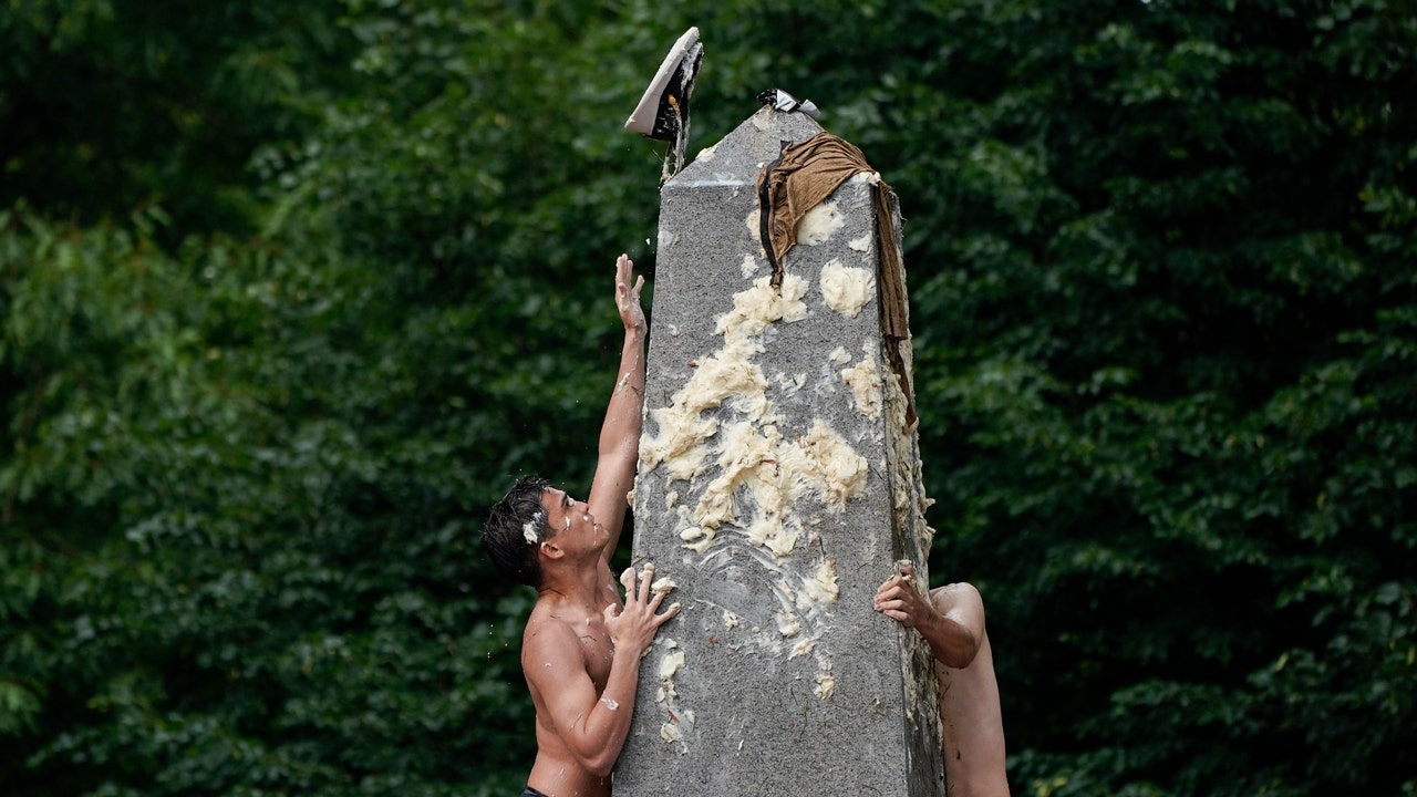 Naval academy plebes scale greased 21-foot herndon monument in annual freshman year tradition