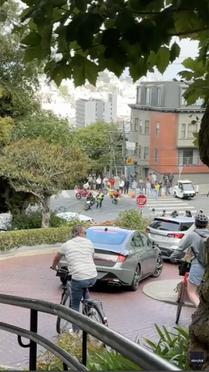 San Francisco traffic officer circled by masked motorcyclists in tourist area