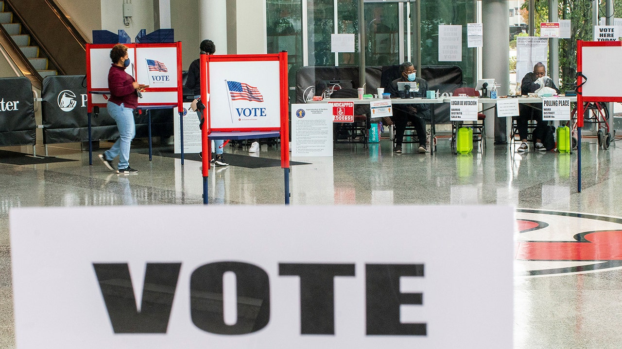 A woman walks to cast her ballot after filling it in a privacy booth while voting in the gubernatorial election in Newark, New Jersey, on Nov. 2, 2021. (REUTERS/Eduardo Munoz)