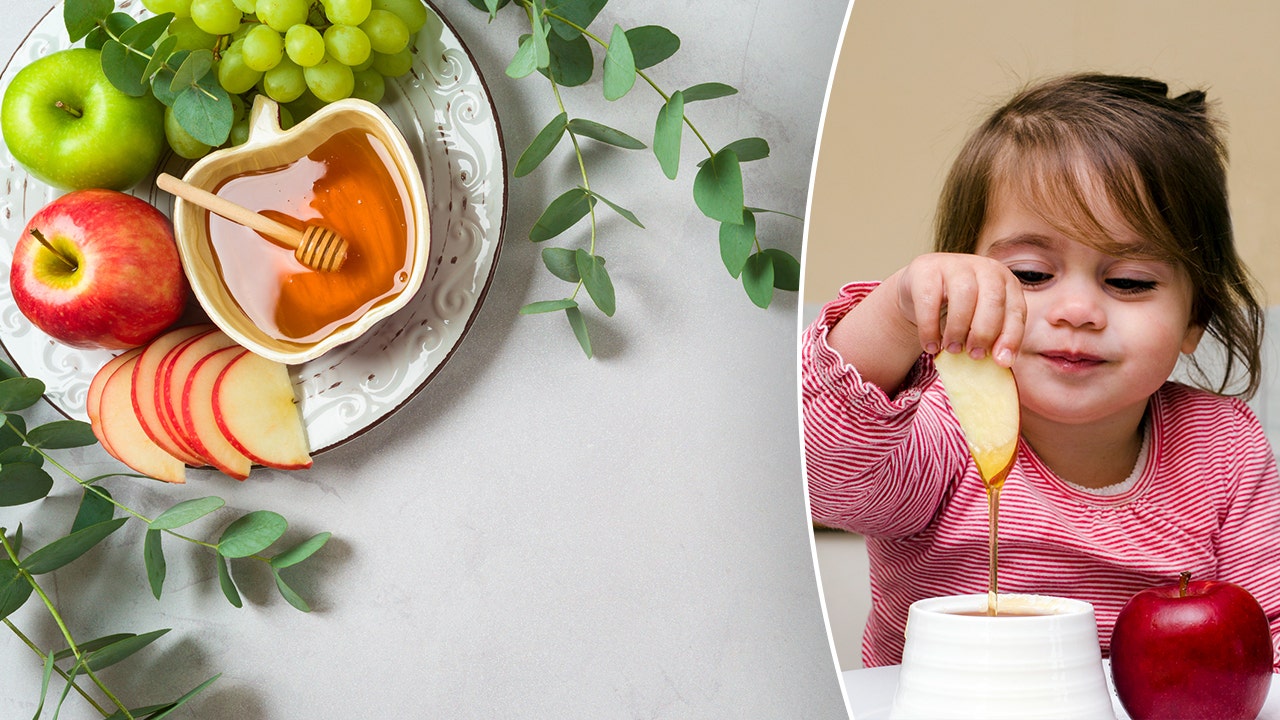 A Jewish girl adheres to a Rosh Hashanah tradition of dipping apples in honey. (iStock)