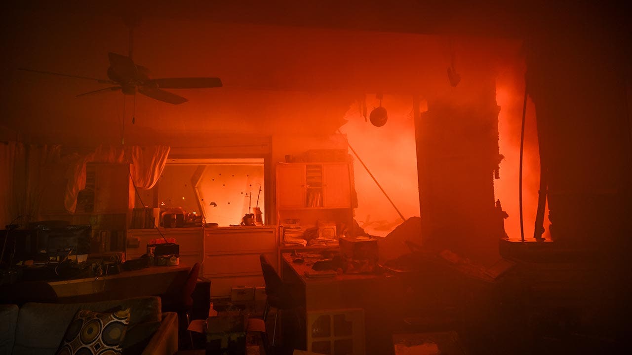 A house in on fire as residents try to escape the site in Pacific Palisades, California, Los Angeles, United States on January 8, 2025. A fast-moving wildfire has forced 30,000 people to evacuate, with officials warning that worsening winds could further escalate the blaze. (Tayfun Coskun/Anadolu via Getty Images)