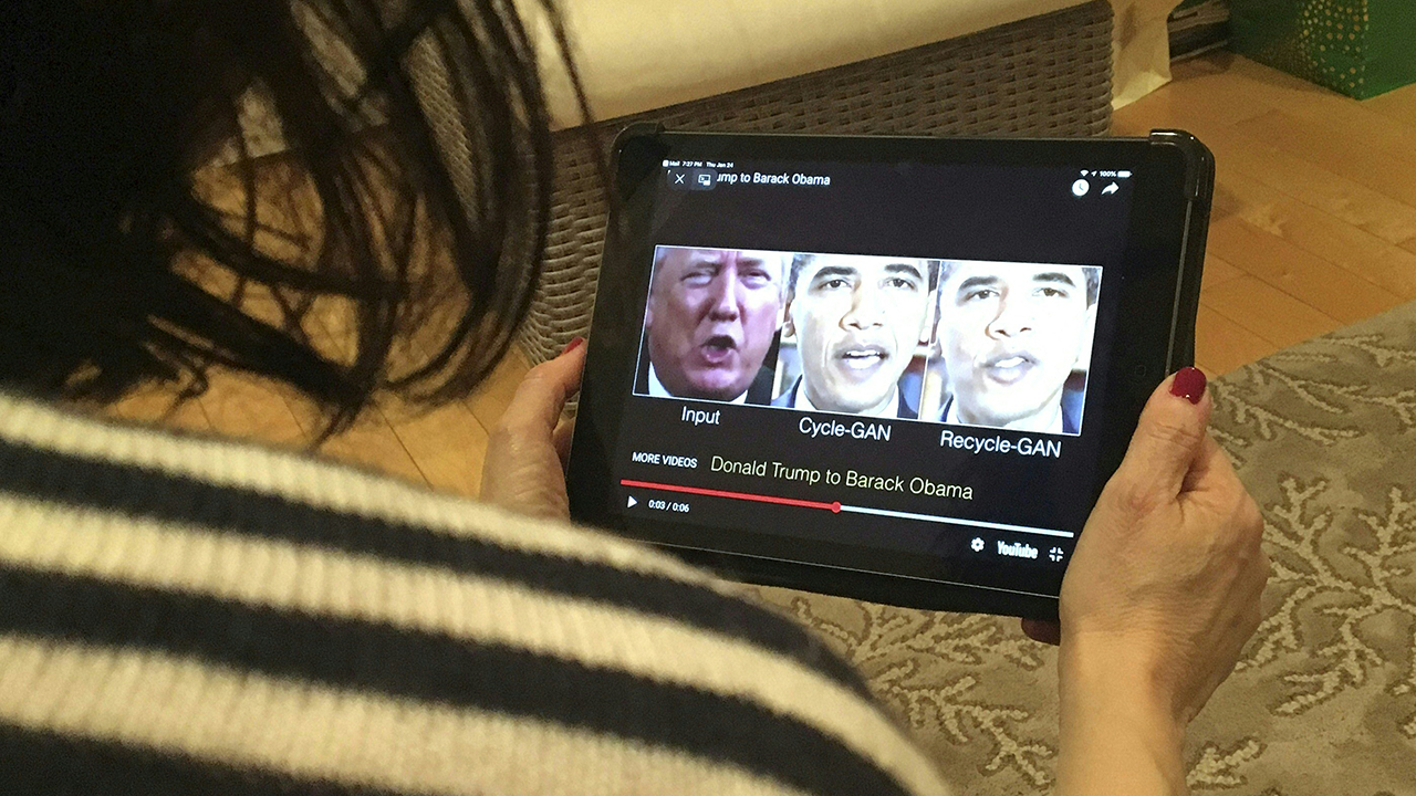 A woman in Washington, D.C., views a manipulated video on January 24, 2019, that changes what is said by President Donald Trump and former President Barack Obama. (Rob Lever /AFP via Getty Images)