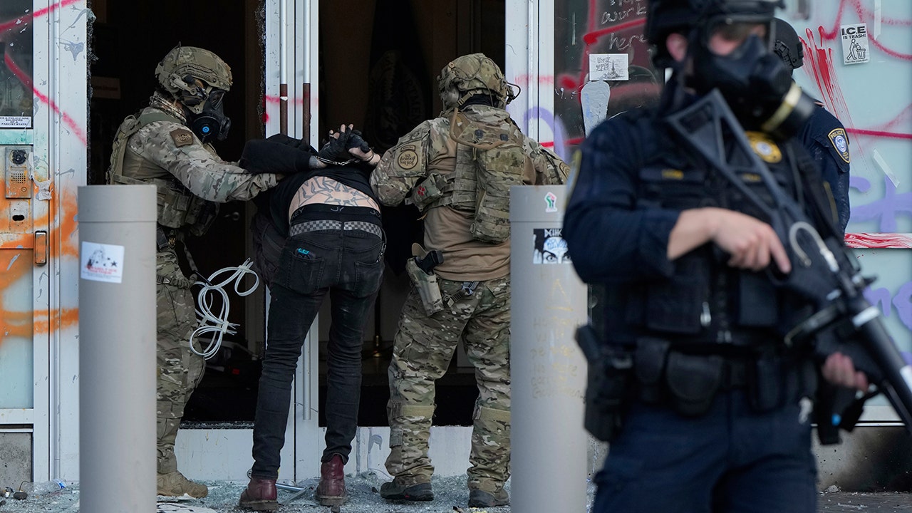 U.S. Customs and Border Protection agents detain a man outside the U.S. Immigration and Customs building during a protest Saturday, June 14, 2025, in Portland, Ore. (AP Photo/Jenny Kane) (AP Photo/Jenny Kane)