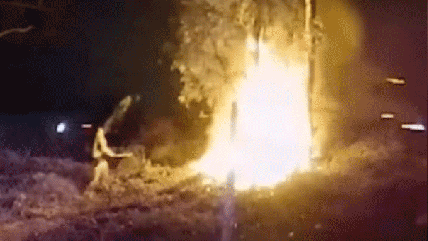 hug fire engulfs car at night as officer tends to scene