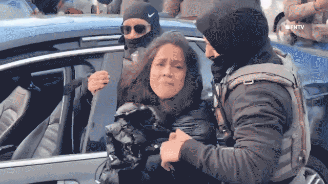 Woman being held by ICE agents after being pulled from her car