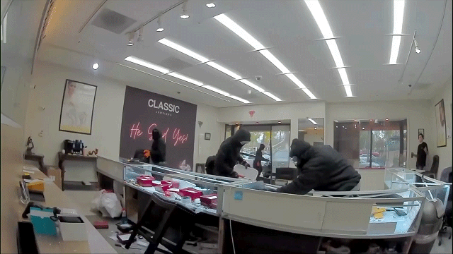 Video shows masked robbers crash car through jewelry store entrance, steal owner's gun in brazen heist