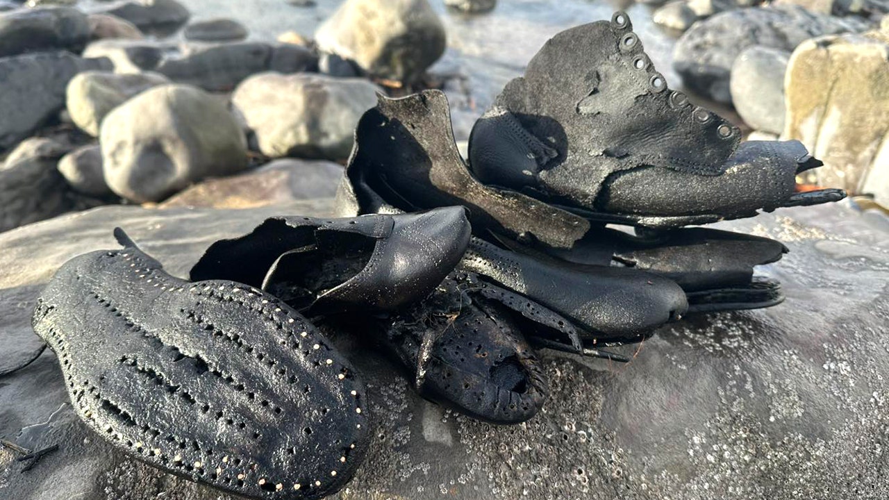 Hundreds of mysterious old shoes wash up on beach during cleanup, baffling officials