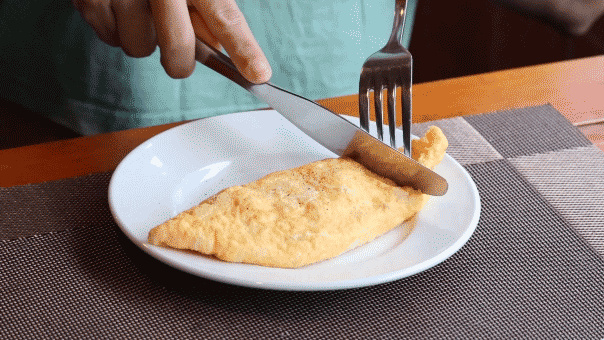 Man cutting omelet