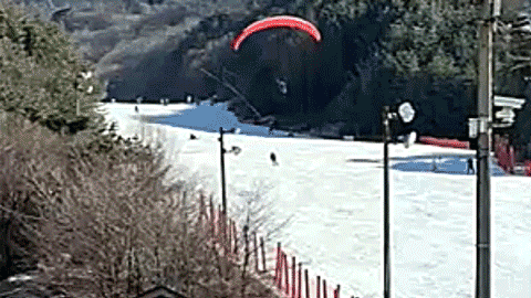Paraglider makes emergency landing on packed ski slope after spending hours in the air