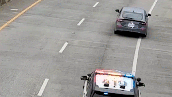 Video shows alleged car thief dangle under bridge after wild chase, sparking tense standoff with police