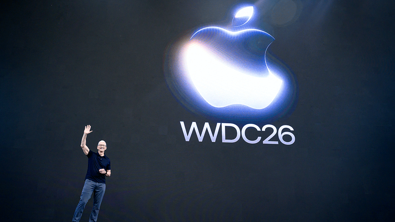 Tim Cook stands on a stage in front of a screen that reads