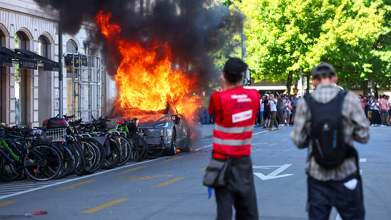 Anti-G7 protest turns violent as demonstrators torch Tesla and smash UN office windows Anti-G7 protest turns violent as demonstrators torch Tesla and smash UN office windows