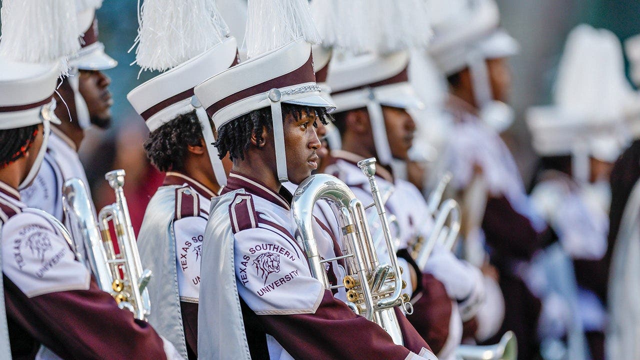 Marching band tuba player unleashes punches on man at college football game without missing a beat