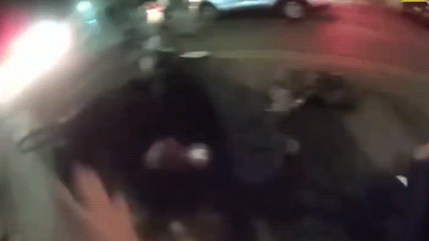 Un agente de policía empuja a una animadora de la ASU durante una detención.